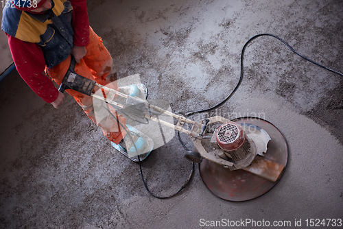 Image of worker performing and polishing sand and cement screed floor