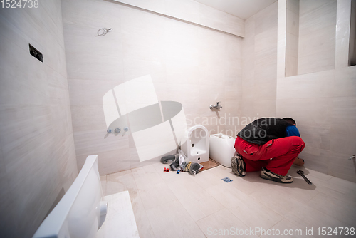 Image of professional plumber working in a bathroom