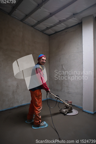 Image of worker performing and polishing sand and cement screed floor