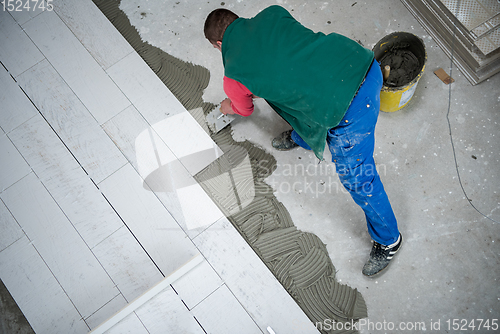 Image of worker installing the ceramic wood effect tiles on the floor