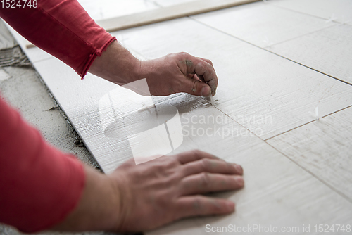 Image of worker installing the ceramic wood effect tiles on the floor