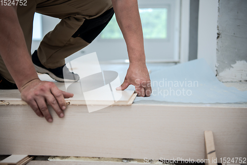 Image of Worker Installing New Laminated Wooden Floor