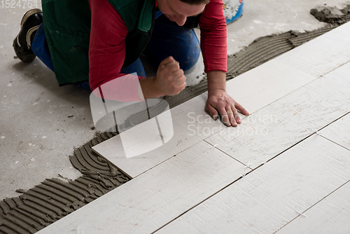 Image of worker installing the ceramic wood effect tiles on the floor