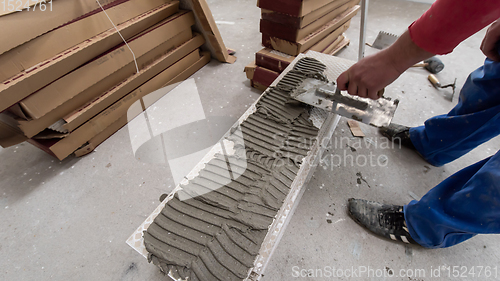 Image of worker installing the ceramic wood effect tiles on the floor