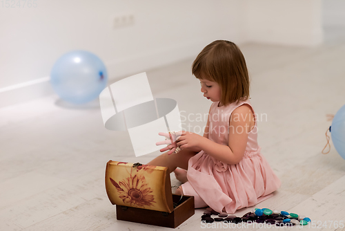 Image of little girl enjoying while playing with mother\'s jewelry