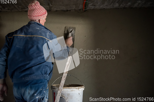 Image of Worker plastering the wall by concrete