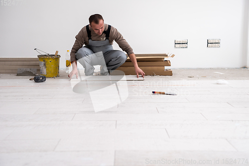 Image of worker installing the ceramic wood effect tiles on the floor