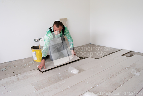 Image of worker installing the ceramic wood effect tiles on the floor