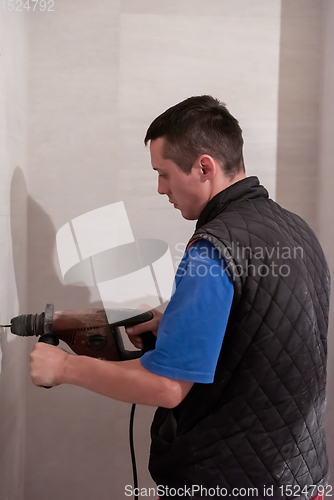 Image of construction worker drilling holes in the bathroom