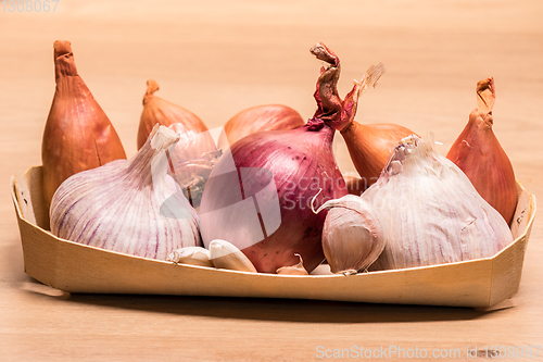 Image of garlic onion shallots in a small wooden basket