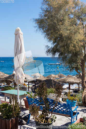 Image of beach with umbrellas and deck chairs by the sea in Santorini