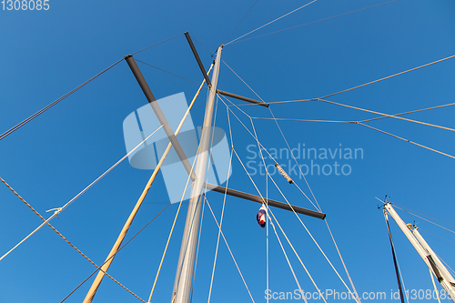 Image of rigging mast and halyards of a sailing boat under a beautiful bl