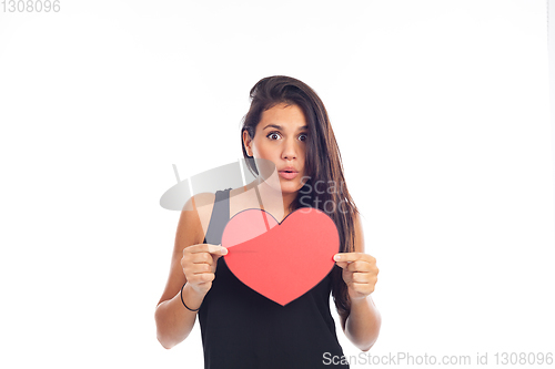 Image of beautiful happy young woman who is holding a big red heart for v