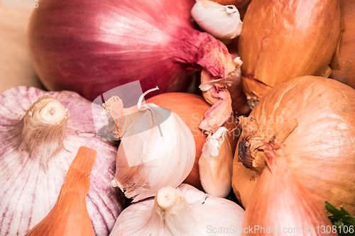 Image of garlic onion shallot parsley on a wooden board