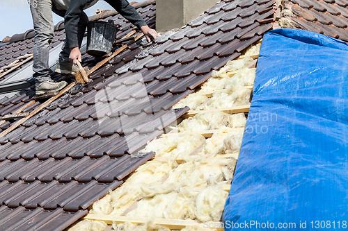 Image of a roofer laying tile on the roof