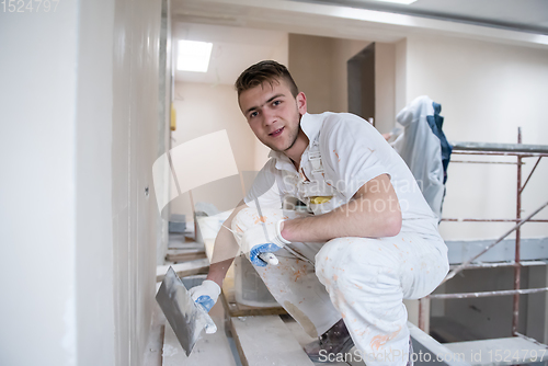 Image of construction worker plastering on gypsum walls