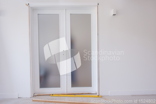 Image of carpenters installing glass door with a wooden frame