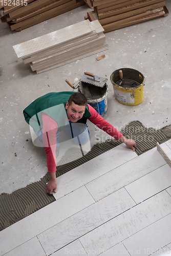 Image of worker installing the ceramic wood effect tiles on the floor