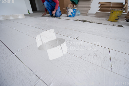 Image of worker installing the ceramic wood effect tiles on the floor