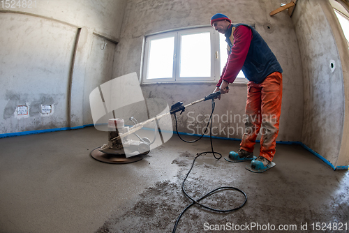 Image of worker performing and polishing sand and cement screed floor