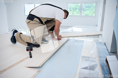 Image of Worker Installing New Laminated Wooden Floor