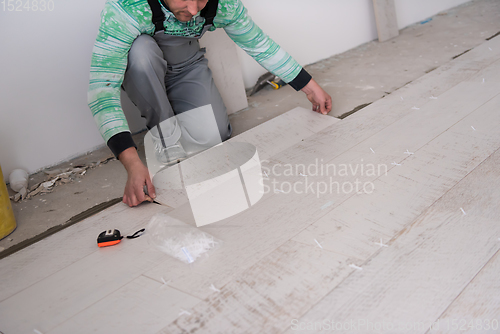 Image of worker installing the ceramic wood effect tiles on the floor