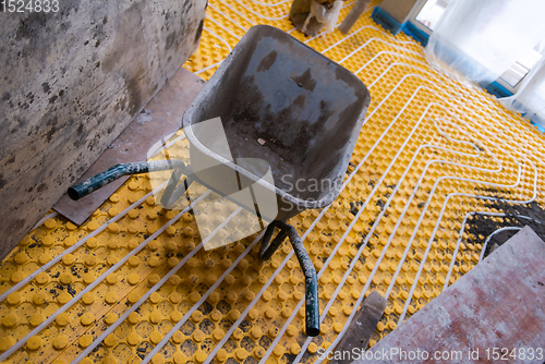 Image of yellow underfloor heating installation with white pipes