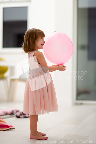 Image of cute little girl playing with balloons