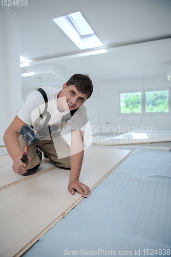 Image of Professional Worker Installing New Laminated Wooden Floor