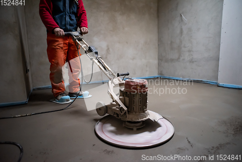 Image of worker performing and polishing sand and cement screed floor