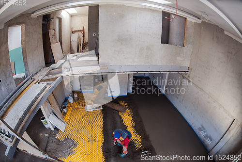 Image of worker performing and polishing sand and cement screed floor