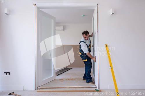 Image of carpenters installing glass door with a wooden frame