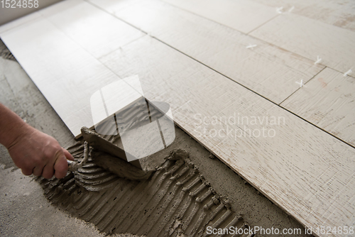 Image of worker installing the ceramic wood effect tiles on the floor