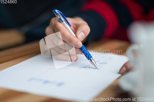 Image of The hand of the designer with a pen sketching his idea