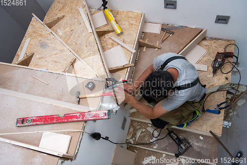 Image of carpenter installing wooden stairs