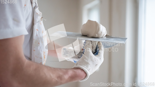 Image of construction worker plastering on gypsum walls