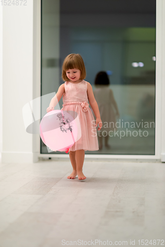 Image of cute little girl playing with balloons