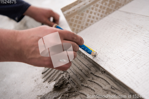 Image of worker installing the ceramic wood effect tiles on the floor