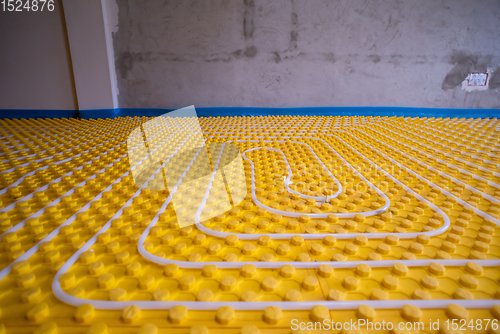 Image of yellow underfloor heating installation with white pipes