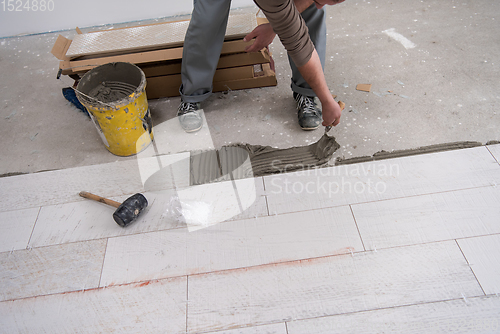 Image of worker installing the ceramic wood effect tiles on the floor