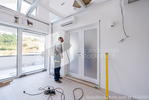 Image of carpenters installing glass door with a wooden frame