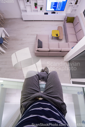 Image of man sitting upstairs on glass floor
