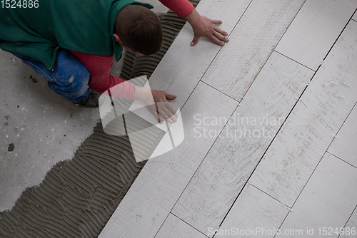 Image of worker installing the ceramic wood effect tiles on the floor