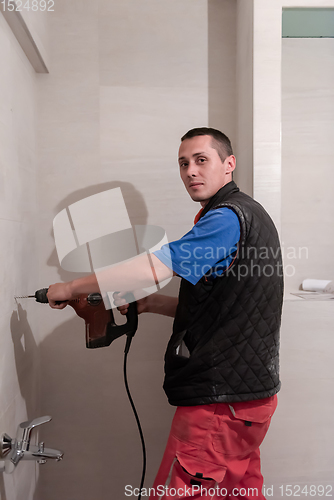 Image of construction worker drilling holes in the bathroom
