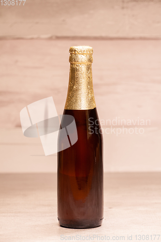 Image of a bottle of blonde beer with golden paper
