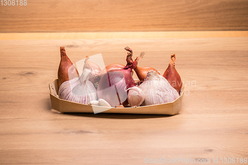 Image of garlic onion shallots in a small wooden basket