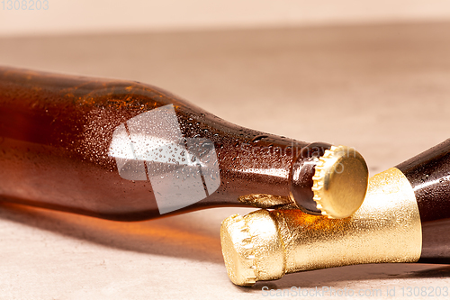 Image of a bottle of blonde beer and a bottle of amber beer lying down