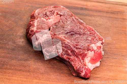 Image of steak of beef on a wooden board
