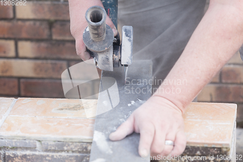 Image of tiler cutting a tile with a grinder