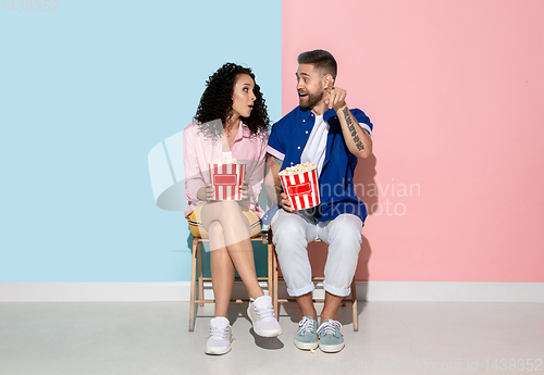 Image of Young emotional man and woman on pink and blue background